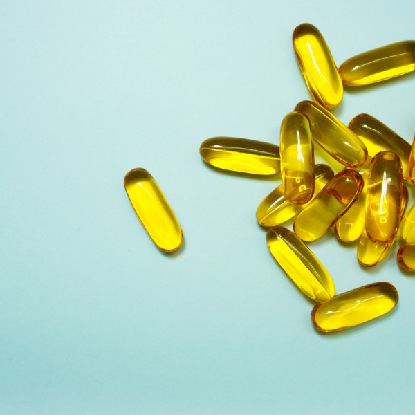 Yellow supplemental pills on a blue background