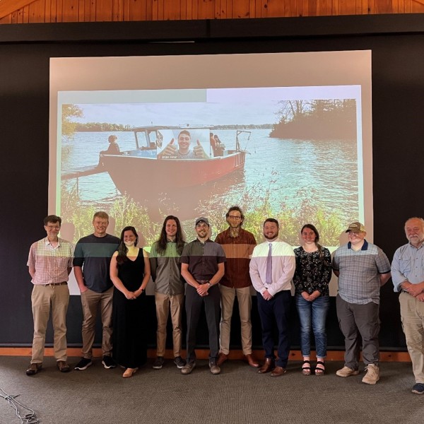 group of graduate students standing in from of projector screen