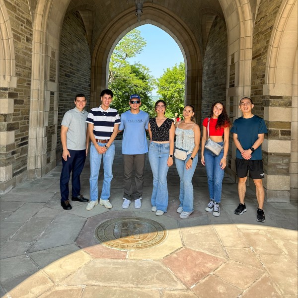 Students stand at arch