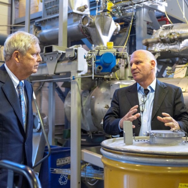 Tom Vilsack, the U.S. secretary of agriculture, talks with Professor Johannes Lehmann, in an industrial facility.