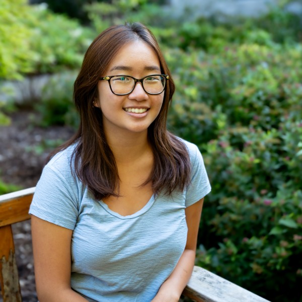 young woman sits on bench