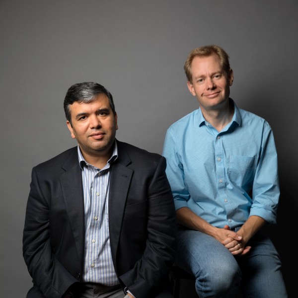 Headshot of two men smiling at the camera. 