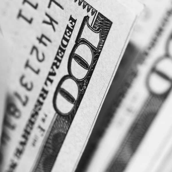 A bundle of one hundred U.S. dollar bills from the side.