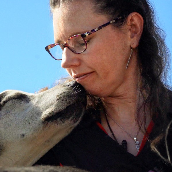 a woman and a dog touch faces
