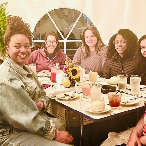 a group of people sit at a table and smile