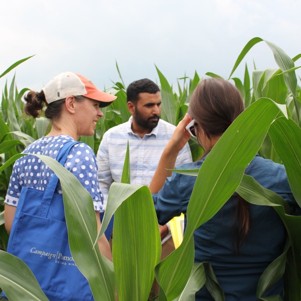 Photo of three people, Jasdeep in the middle, and the other two facing away from the camera on either side.