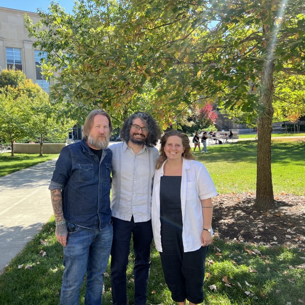 Three people pose for photo on ag quad.