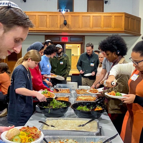 Students serving themselves food down a long table.