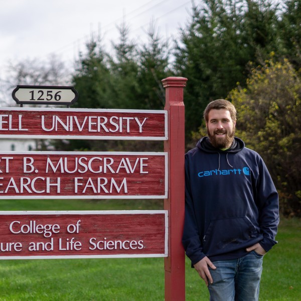 Brian Lanphere standing next to the Musgrave Research Farm sign