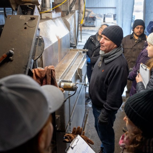 Cornell professor Johannes Lehmann, center, examines the biochar kiln at Spruce Haven Farm with officials from NYSERDA and Arcadis