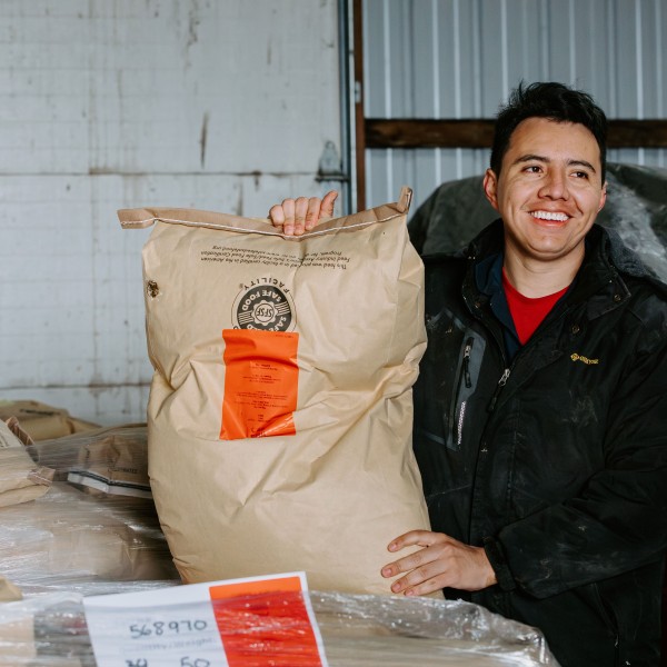 a man holds up a bag of cow feed