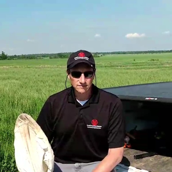 Person wearing CCE garb, sitting on a truck tailgate with a net