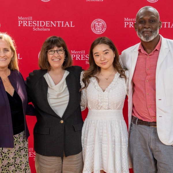 4 individuals stand in front of cornell backdrop