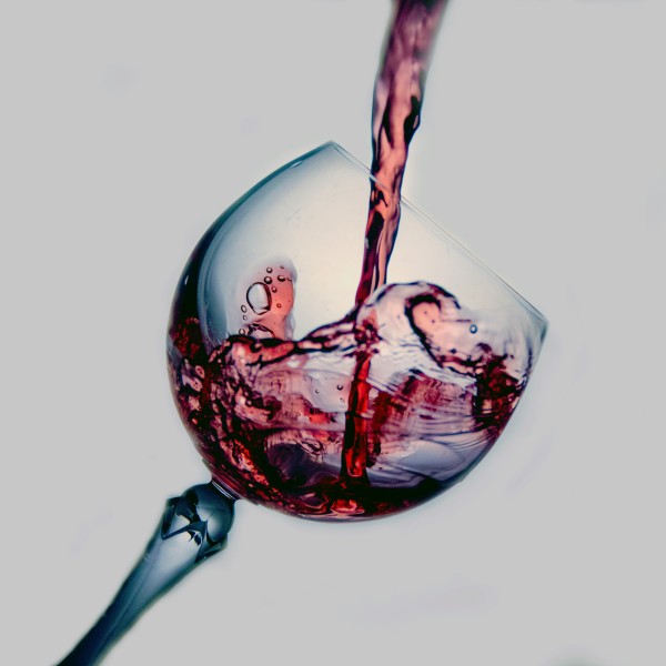 Red wine being poured into a clear glass.