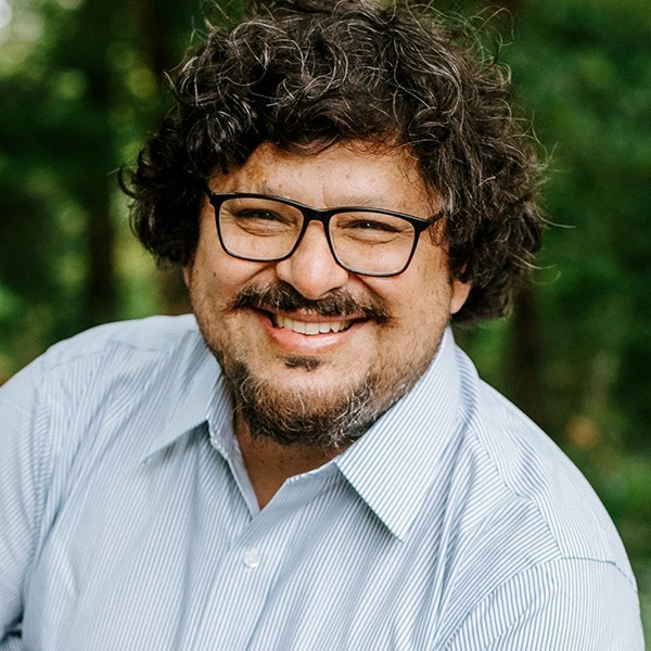 Headshot of Mario Herrero. A man with a mustache, glasses, and curly brown hair.