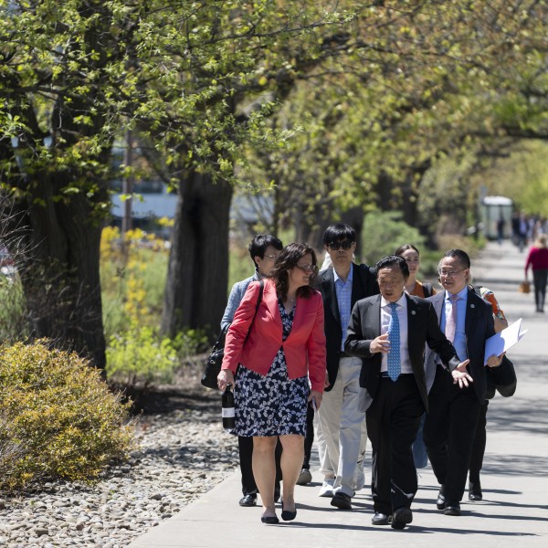 Julie Suarez, associate dean of Land-Grant affairs walks with Qu Dongyu, director-general of the UN FAO, Xingen Lei, associate dean of research and innovation and UN FAO team members. 