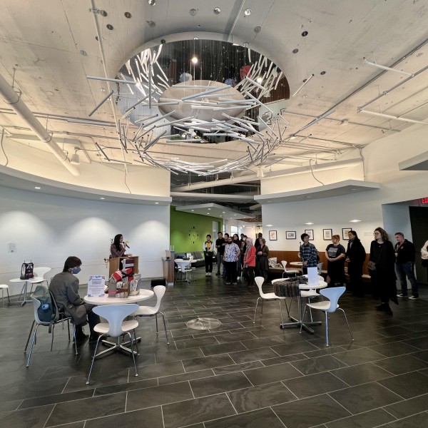 woman giving speech with an audience standing around her