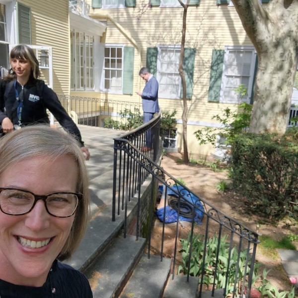 woman smiling in selfie in front of house