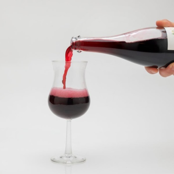 A hand pouring a bottle of wine into a wine glass