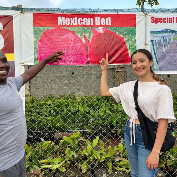 Two individuals show dragon fruit banner