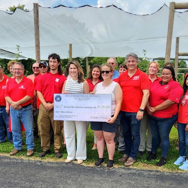 Sarah Dressel-Nikles '11, right with check, president of the Hudson Valley Research Laboratory board, New York State Sen. Michelle Hinchey (D-41st), left with check, and Jared Buono, director of the lab with CALS leaders, lab staff and board, and members of the New York Farm Bureau.