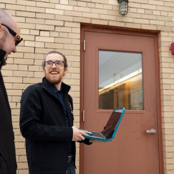 Alistair Hayden, right, speaks with Adam Hughes outside a building