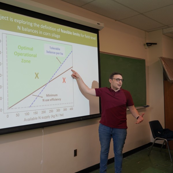 Man pointing at slideshow and talking.