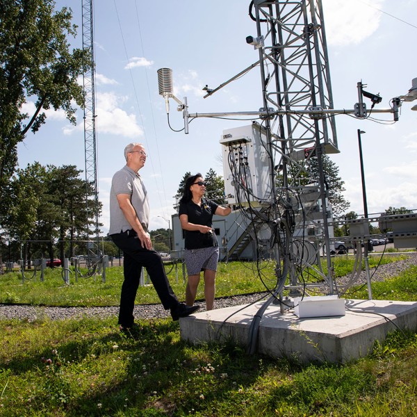 two people standing next to a weather station