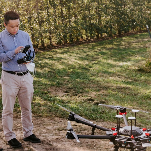 Yu Jiang operates a research drone with a graduate student.