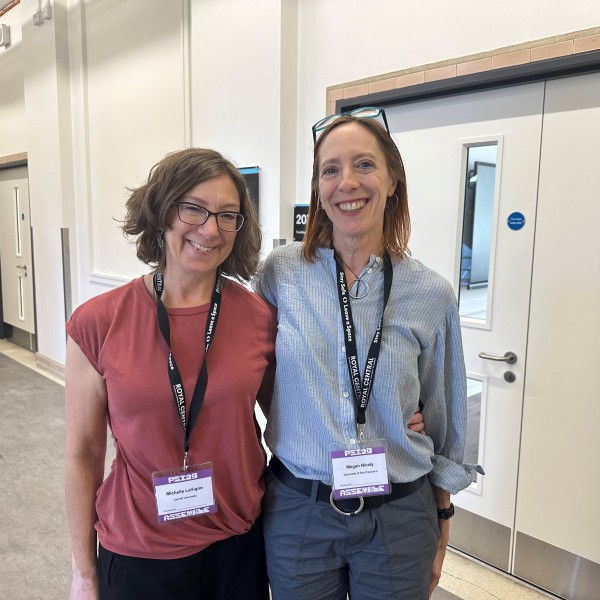 Michelle and Megan against wall smiling for picture