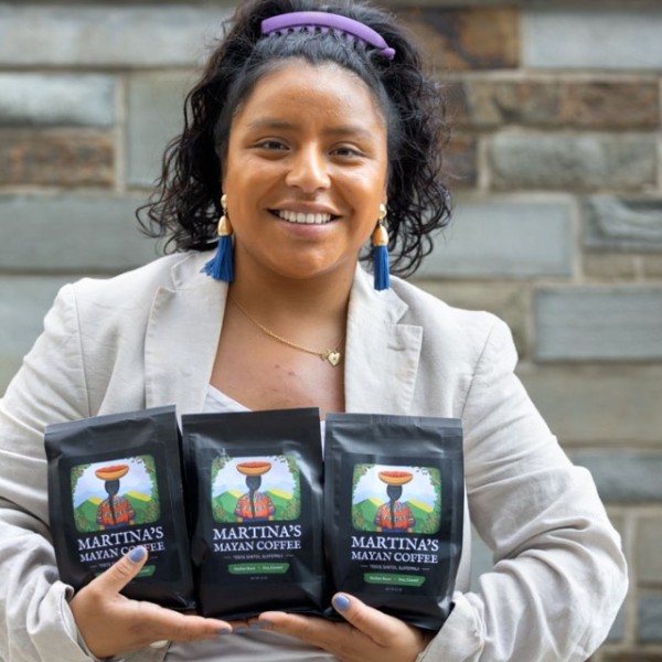 Cornell student holding coffee bags. 