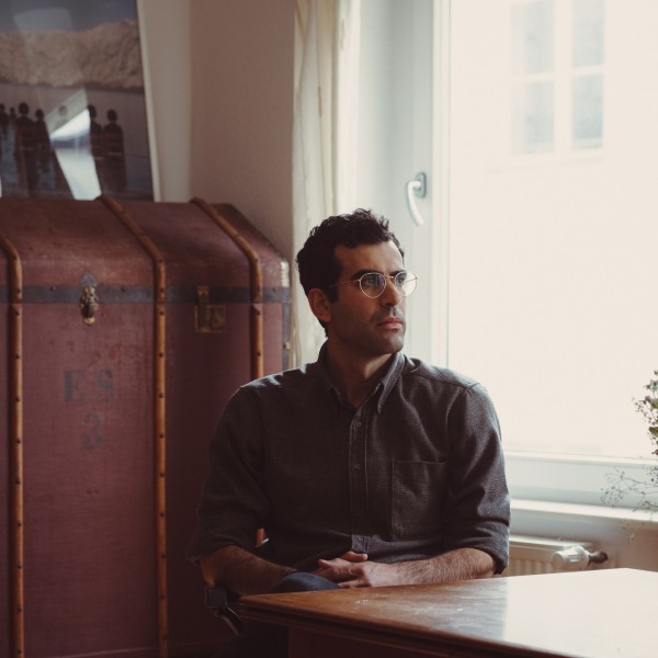 image of aaron benanav sitting at a table