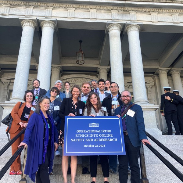 group of individuals stand on the steps to a building