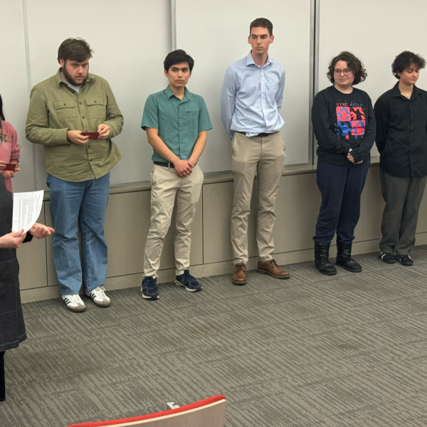 students standing in front of class while Professor LaVigne announces student winners