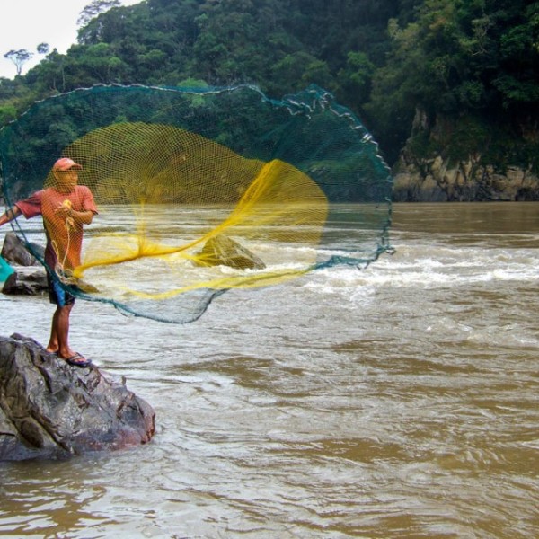 Fishermen cast their nets in the Amazon River.