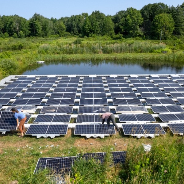 Researchers install installed floating solar panels at the Cornell Experimental Pond Facility in 2023