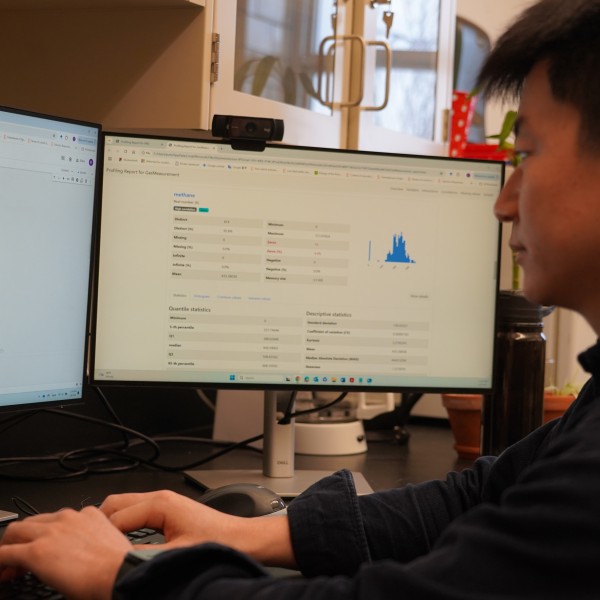 a man looks at data on two computer screens