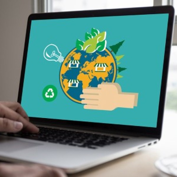 Laptop displaying a graphic of the planet with tree, recycling, light bulb, and hands icons