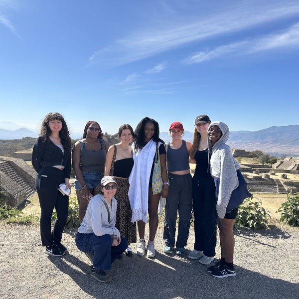 students and professor pose amidst mountain scene
