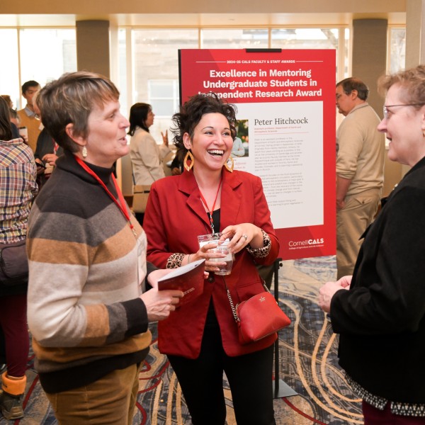 Three women gather in a semi-circle at an event