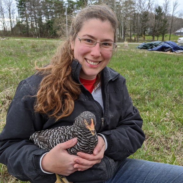 Amy Barkley holding a chicken on her farm.