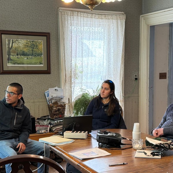 A group of people have a discussion while a presentation is being given.