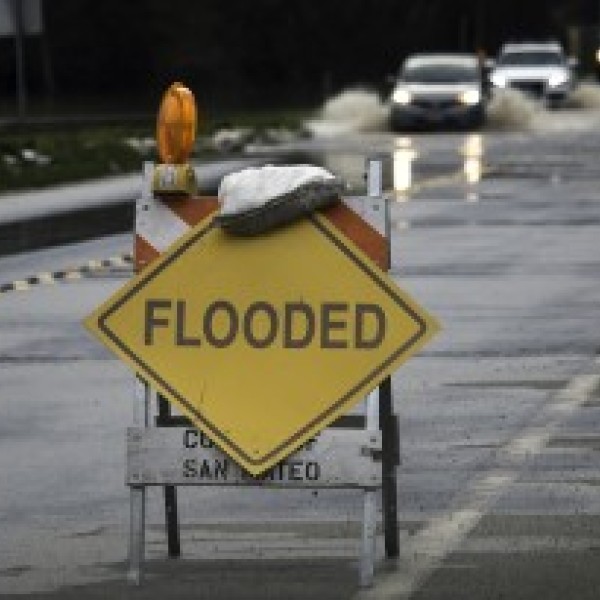 Warning side on a flooded road that reads 'flooded.'