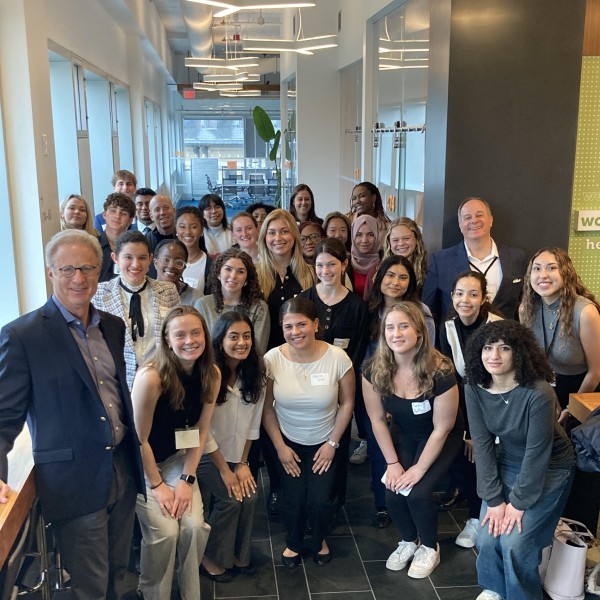 large group poses in comm hallway with some students squatting in front
