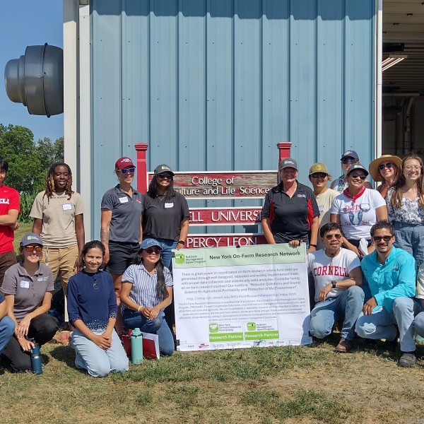 A group smiles around a poster.