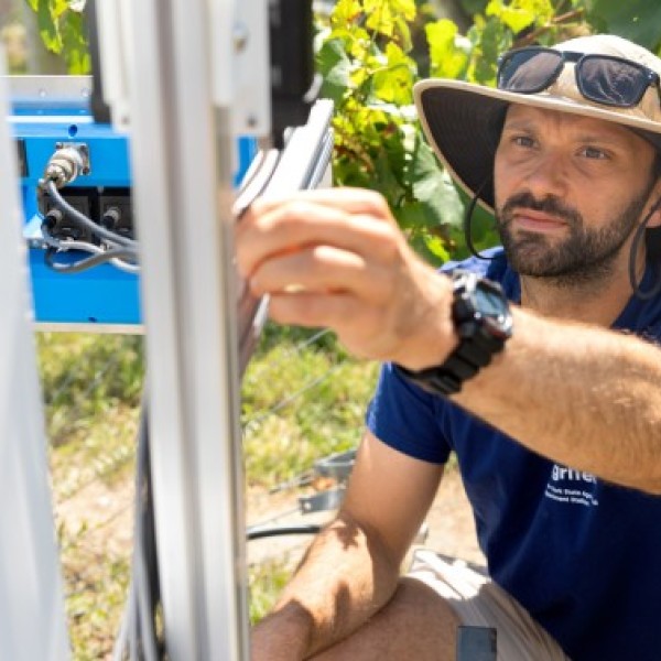Robotics technician Cole Regnier works on an autonomous robot designed to detect disease on grapevines on the Cornell AgriTech campus in Geneva, New York.