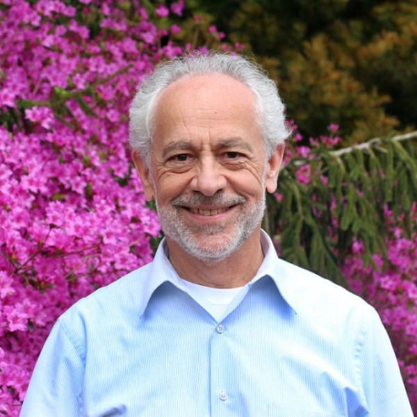 Headshot of Christopher Dunn next to blooming flowers