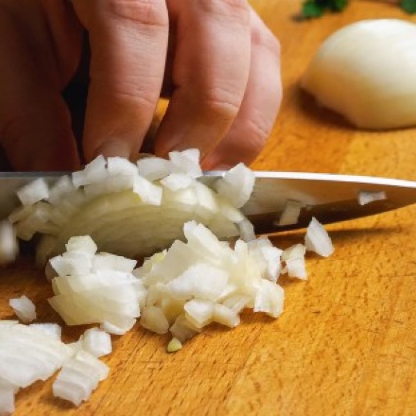 Onions being chopped with a knife.