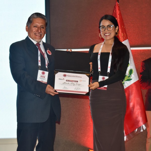 person receiving award and shaking other person's hand