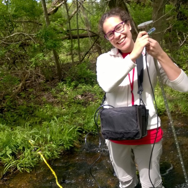 Person standing in ankle-high water taking measurements